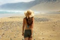 Woman in straw hat walking on a tropical beach who looking like an incredible martian landscape.