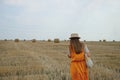 A woman in a straw hat walks along a field Royalty Free Stock Photo