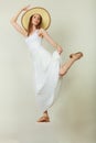 Woman in straw summer hat white dress jumping