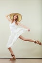 Woman in straw summer hat white dress jumping
