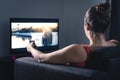 Woman streaming movie or watching series. Person using smart tv remote control to choose film or change channel. Royalty Free Stock Photo