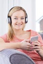 Woman Streams Music From Mobile Phone To Wireless Headphones Royalty Free Stock Photo