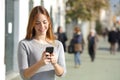 Woman in the street browsing a smart phone