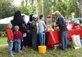 Woman street seller selling fast food for children standing in a line in front of a food moving store