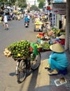 Woman street vendor selling large green fruit in Vietnam