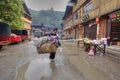 Woman street vendor with a yoke on his shoulder.