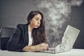 Woman stressed by overwork with the laptop melting