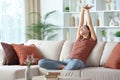 Woman stretching arms at home on a couch Royalty Free Stock Photo