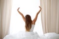 Woman stretching in bed after wake up, back view, entering a day happy and relaxed after good night sleep. Sweet dreams Royalty Free Stock Photo