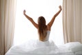 Woman stretching in bed after wake up, back view, entering a day happy and relaxed after good night sleep. Sweet dreams Royalty Free Stock Photo