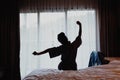 Woman stretching on bed after wake up, back view Royalty Free Stock Photo