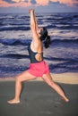 Woman stretching her arms and doing sport at sea with sunrise Royalty Free Stock Photo