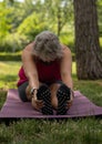 Woman stretching in a park, touching both feet