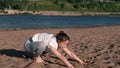 Woman stretching yoga on the beach by the river in the city. Beautiful view. Vinyasa.