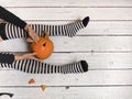 Woman in striped stockings preparing pumpkin for Halloween Royalty Free Stock Photo