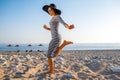 Woman in stripped dress with a hat on the beach Royalty Free Stock Photo