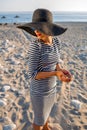 Woman in stripped dress with a hat on the beach Royalty Free Stock Photo