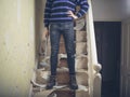 Woman stripping wallpaper on stairs