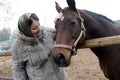 Woman strokes a horse head