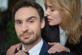 Woman stroking male shoulders. Passionate couple of two Caucasian business people. Close up portrait. Selective focus on Royalty Free Stock Photo