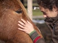 Woman stroking a piebald pony