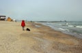 Woman strolling along the beach with the dog