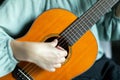 Woman strumming strings of wooden solid acoustic guitar Royalty Free Stock Photo