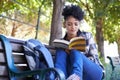 Woman, student and book on bench for studying university, education or reading. Female person, academic and park on Royalty Free Stock Photo