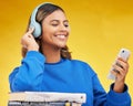 Woman, student and phone in studio with headphones, books and thinking with smile by yellow background. Gen z girl