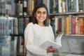 Woman, student and portrait reading in college library with smile for research, learning and education. Happy, female Royalty Free Stock Photo