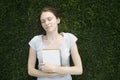 Woman student is preparing for college tuition while sitting with notepad outside