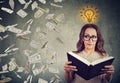 Student reading a book has a bright idea how to earn money Royalty Free Stock Photo