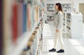 Woman, student and research in library for books, knowledge or learning at bookstore for education. Female looking at Royalty Free Stock Photo