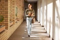 Woman, student and university hallway with a person walking ready for learning and study. Smile, college and back to Royalty Free Stock Photo