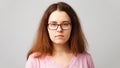 Woman studio portrait. Serious young woman in glasses