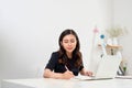 Woman studying with laptop and taking notes on a desktop at home Royalty Free Stock Photo