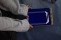 Woman studying on top of a blue background with a closed book