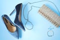 Woman styled fashion clothes and accessories on light blue background.
