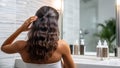 Woman styling her hair in bathroom Royalty Free Stock Photo