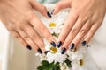 Woman with stylish color nails and chamomile flowers, closeup Royalty Free Stock Photo