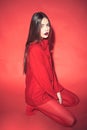 Woman with stylish makeup and long hair posing in total red outfit. Fashion concept. Girl on calm face in red formal