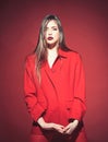 Woman with stylish makeup and long hair posing in total red outfit. Fashion concept. Lady with dark lips looking at