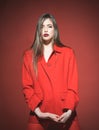 Woman with stylish makeup and long hair posing in total red outfit. Fashion concept. Lady with dark lips looking at