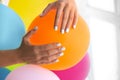 Woman with stylish nails holding color balloon, closeup