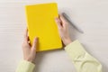 Woman with stylish notebook and pen at white wooden table, top view Royalty Free Stock Photo