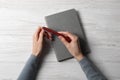 Woman with stylish notebook and pen at white wooden table, top view Royalty Free Stock Photo