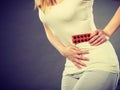 Woman suffer from belly pain holds pills