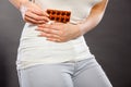 Woman suffer from belly pain holds pills