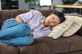 woman suffering from abdominal pain lying on the couch at home Female suffering from severe spasms holding her stomach