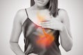 Woman suffering from acid reflux or heartburn against gray background